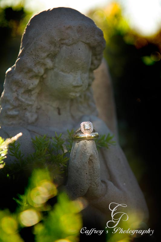 Unique photo of the wedding rings being held by an Angel in the garden at the Phoenix Rising. 
