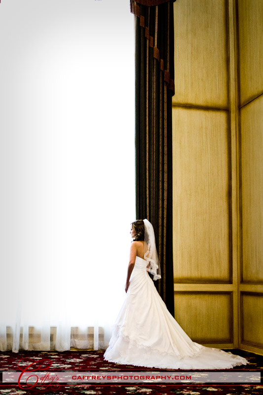 Bride in front of the massive window during her bridal portraits Ashelynn Manor. 