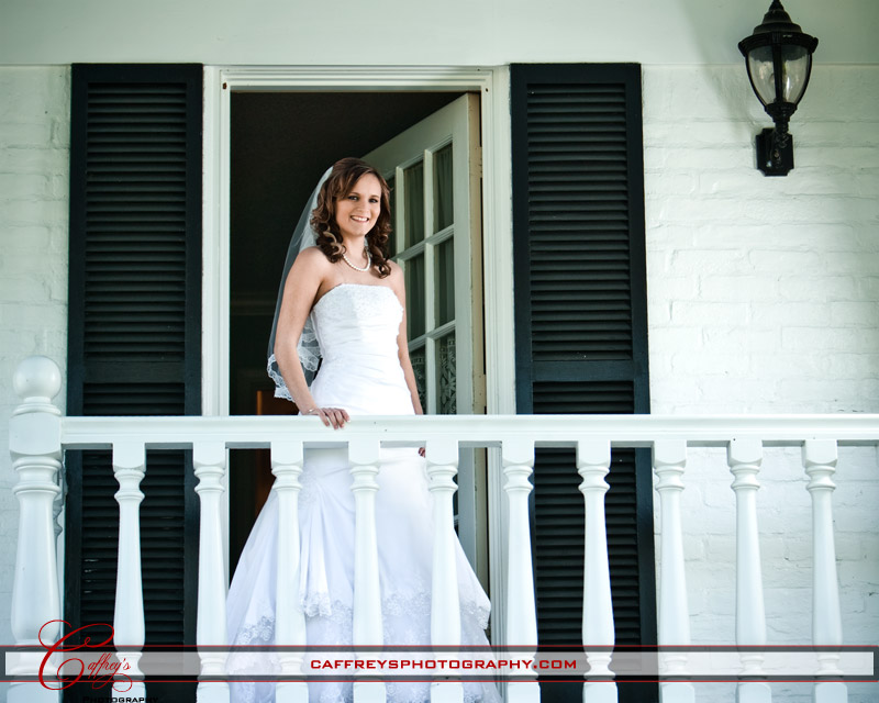 Captivating bride on the balcony as she waits for her bridal portraits Ashelynn Manor. 