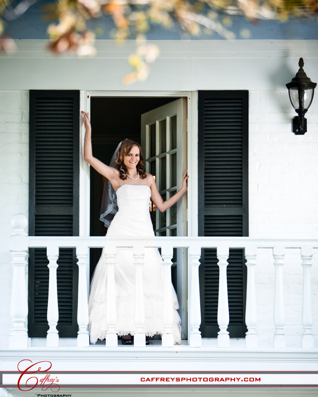 Bride in the doorway of the balcony at Ashelynn Manor. 