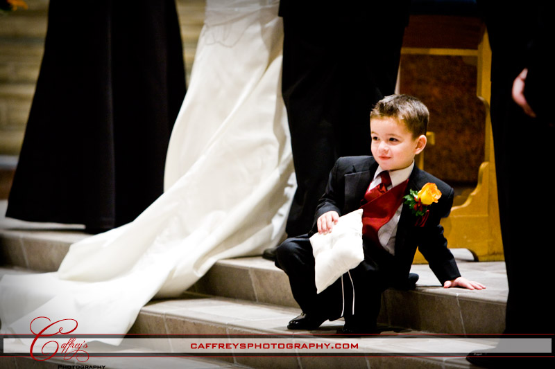 Cute ring bearer sitting on the steps of the church. 