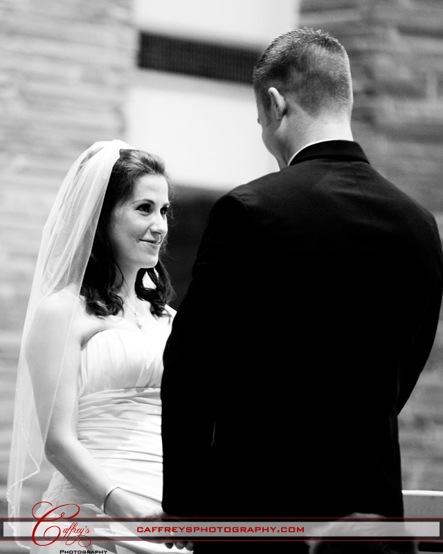 Beautiful bride smiling at her groom as he gazes at her during their wedding. 