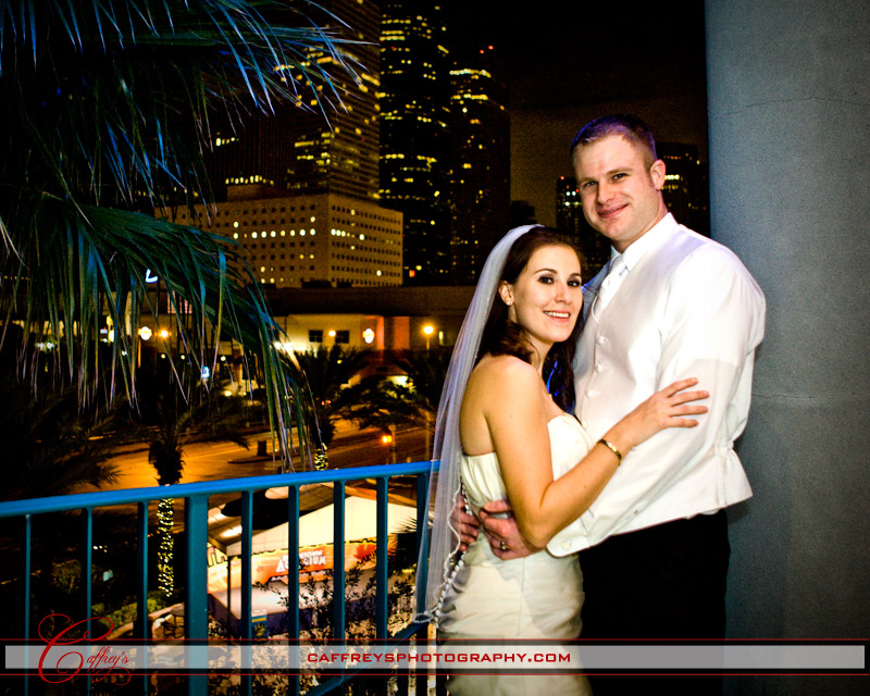 Beautiful newly wed couple cuddling out side with Downtown Houston Skyline in the background. 