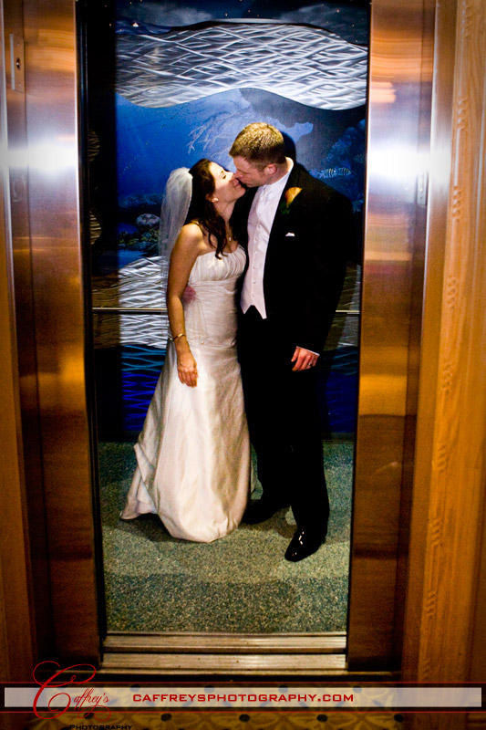 Bride and groom stealing a kiss in the elevator at the Downtown Aquarium in Houston.