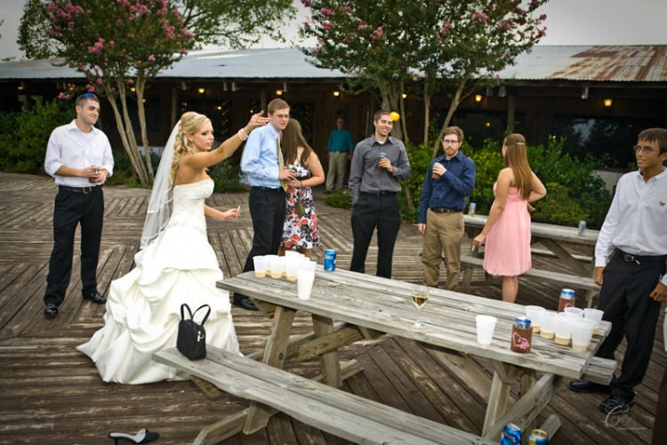 Bride Playing beer pong during their safari texas ranch wedding.