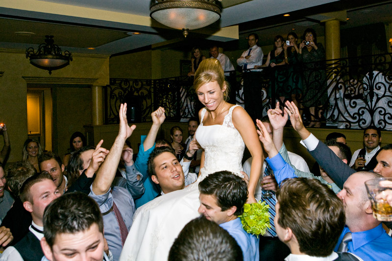 Bride being carried by the grooms fraternity brothers at their wedding reception. 