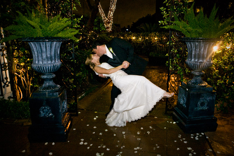 Stunning courtyard decorated in twinkling lights as the dips his bride and kisses her. 