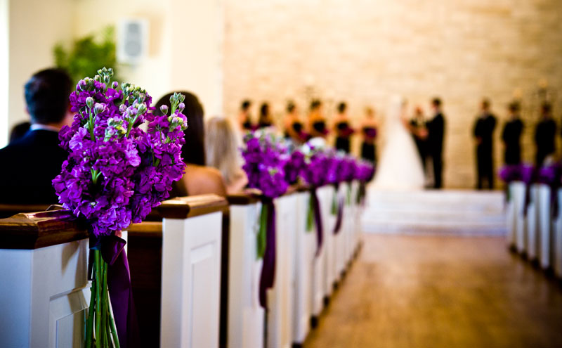 Pretty flowers adorn the pews during the wedding at Brisoe Manor. 