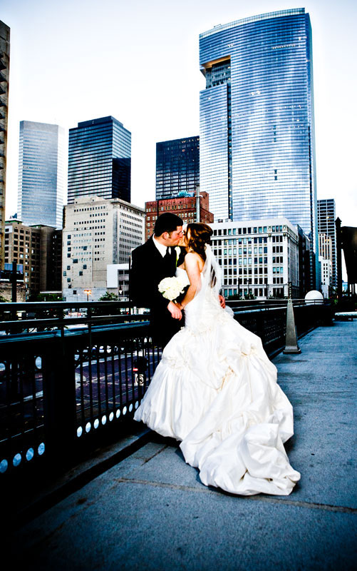 Beautiful bride and her groom kissing under the Houston City Skyline. 