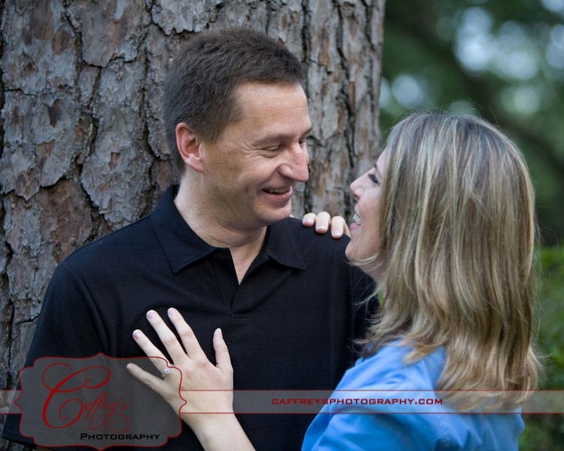 Engaged couple in love standing in the Pine Trees.