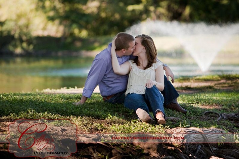 Newly engaged couple kissing in the park at Texas State University.