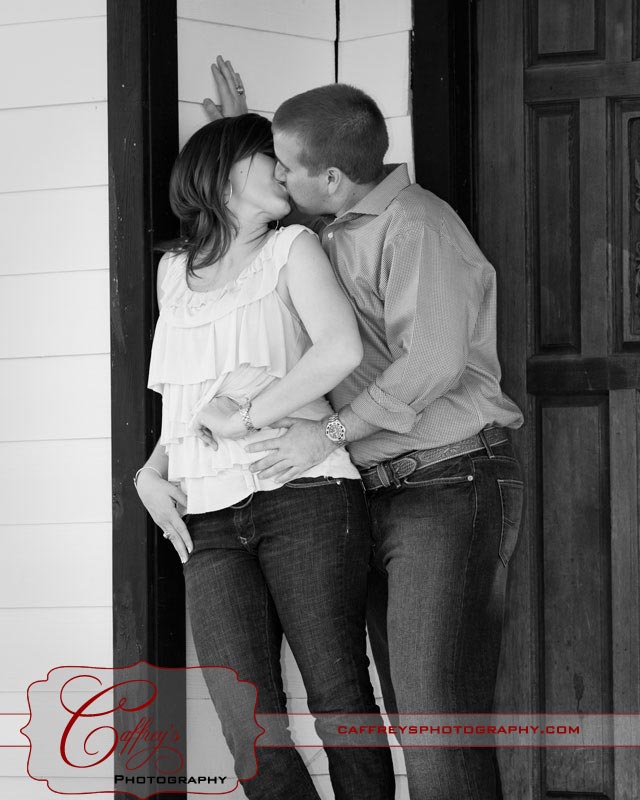 Sweet engagment couple kissing on the porch in San Marcos Tx.
