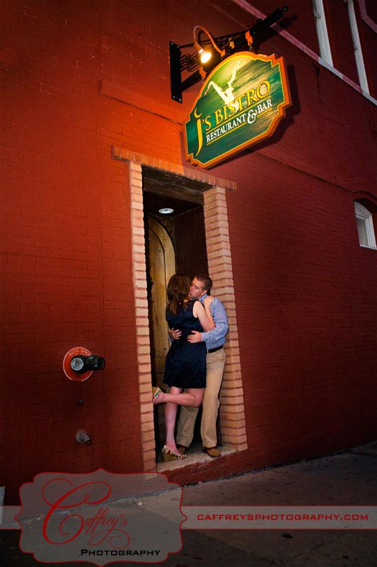 Sexy bride to be kissing her groom under the j's Bistro sign in San Marcos Tx.